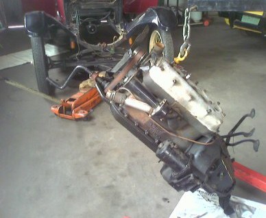Hoisted high, the Model T engine comes out Hoisted high, the Model T engine comes out